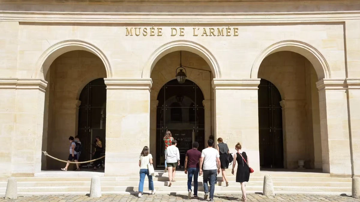 People walking towards the arched entrance of the 