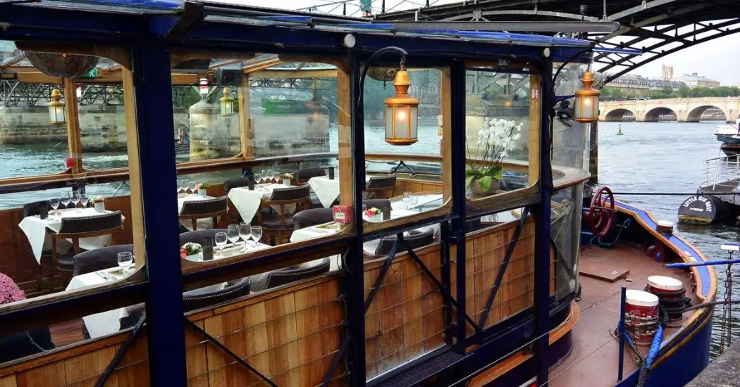 Romantic Paris Seine cruise boat with fine dining setting.