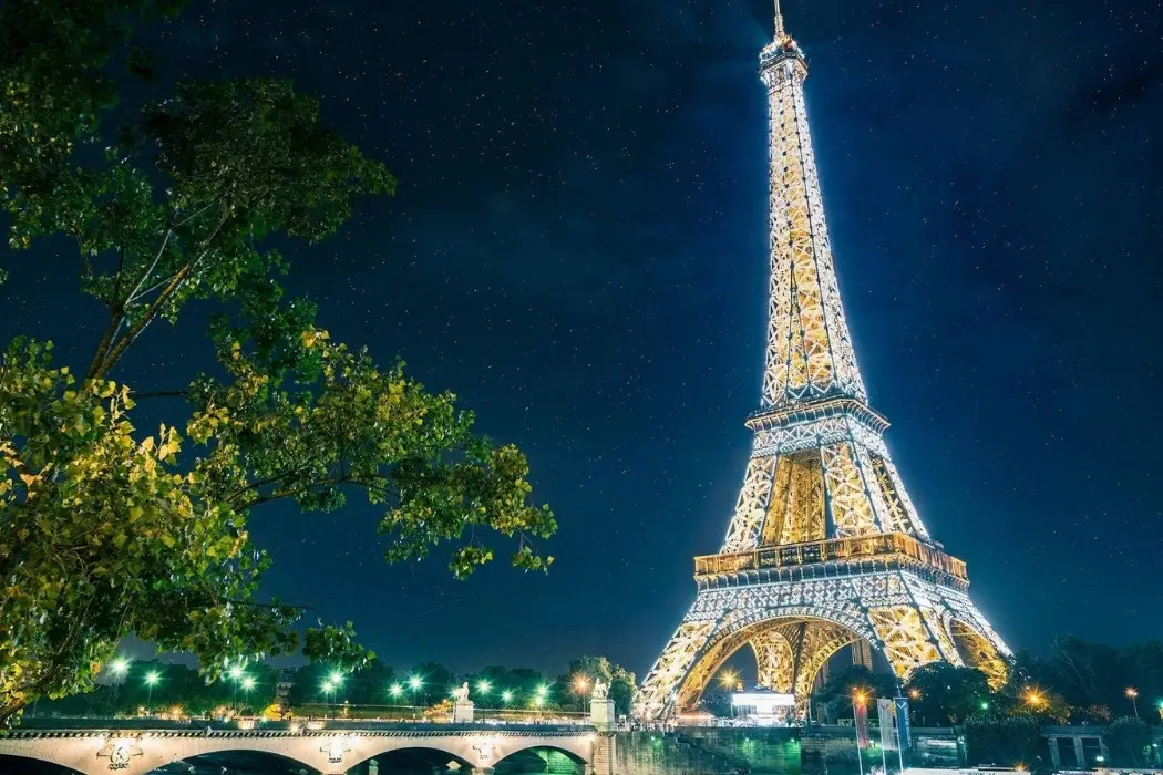 Eiffel Tower lit up near Seine River at night 