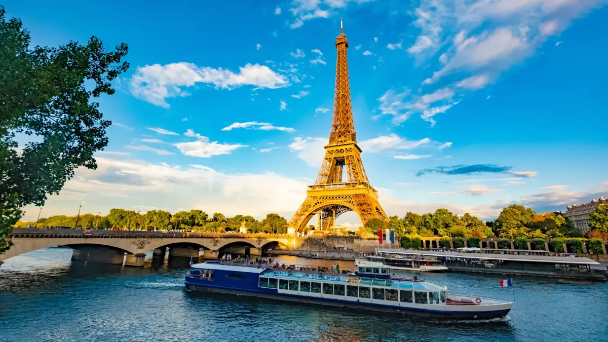 Sightseeing boat passing near the Eiffel Tower during a Seine River cruise in Paris