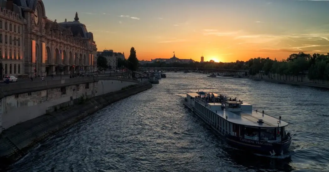 Capitaine Fracasse cruise boat passing Musée d'Orsay at sunset.