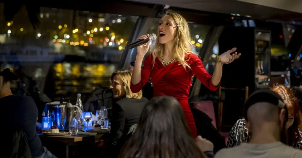 Singer performs live on a cruise with guests enjoying dinner.
