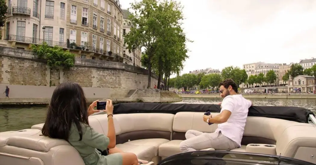 Woman taking a photo on a luxury Seine River boat ride.
