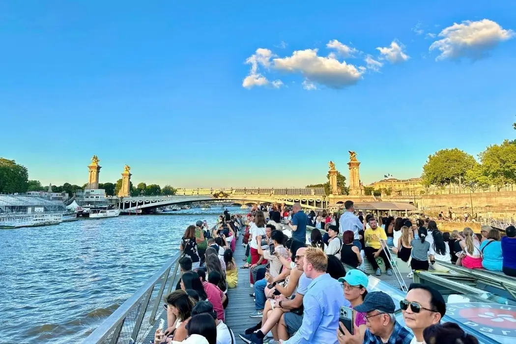 Crowded Paris boat cruise with clear blue sky background