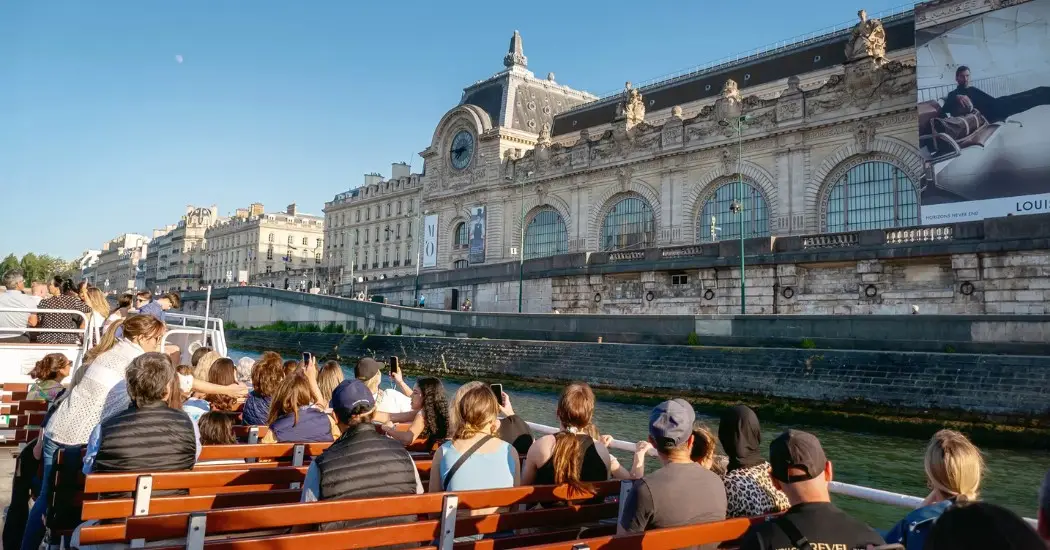 Tourists enjoy a Seine River cruise passing the Musée d'Orsay in Paris.