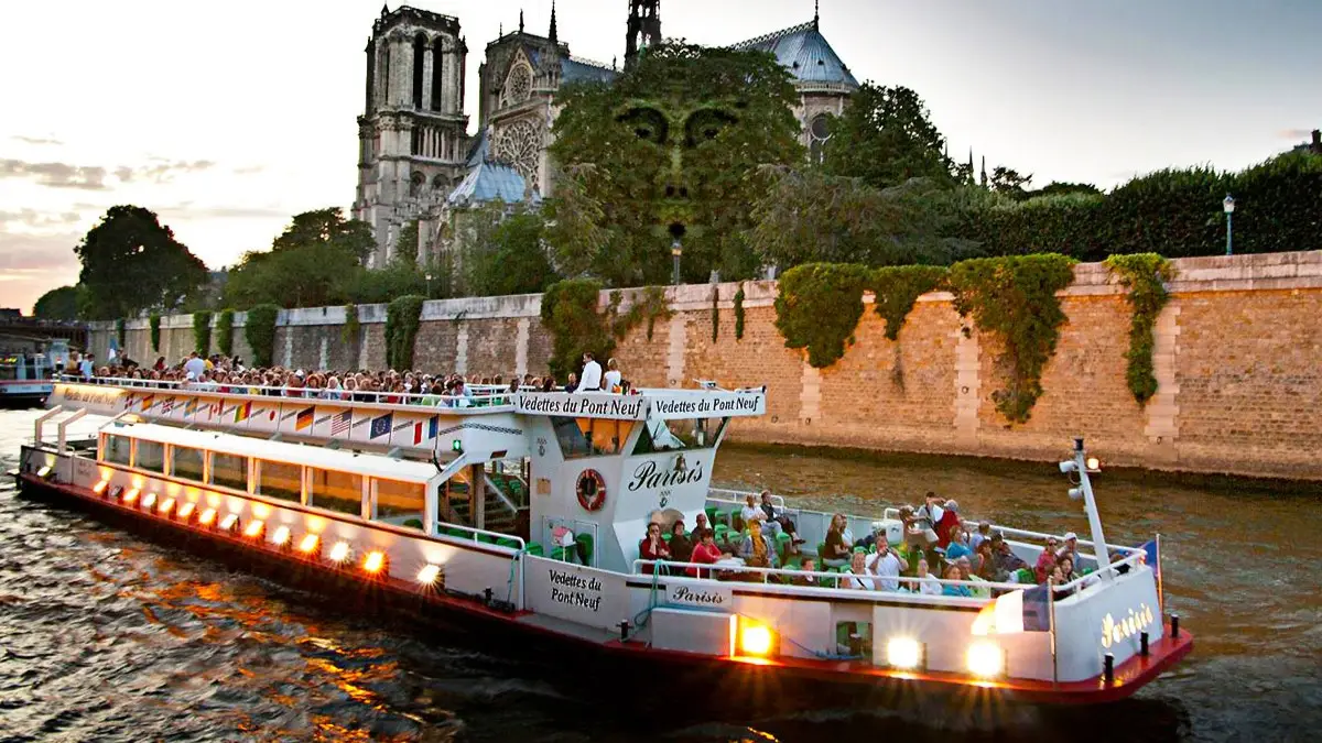 Seine River cruise boat passing Notre Dame at sunset. Seine River cruise boat passing Notre Dame at sunset.