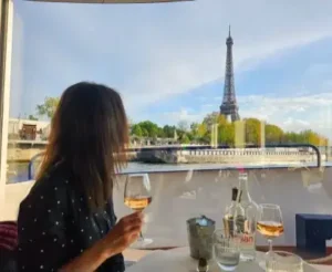 Woman enjoying a glass of wine on a Seine River cruise with a view of the Eiffel Tower in Paris